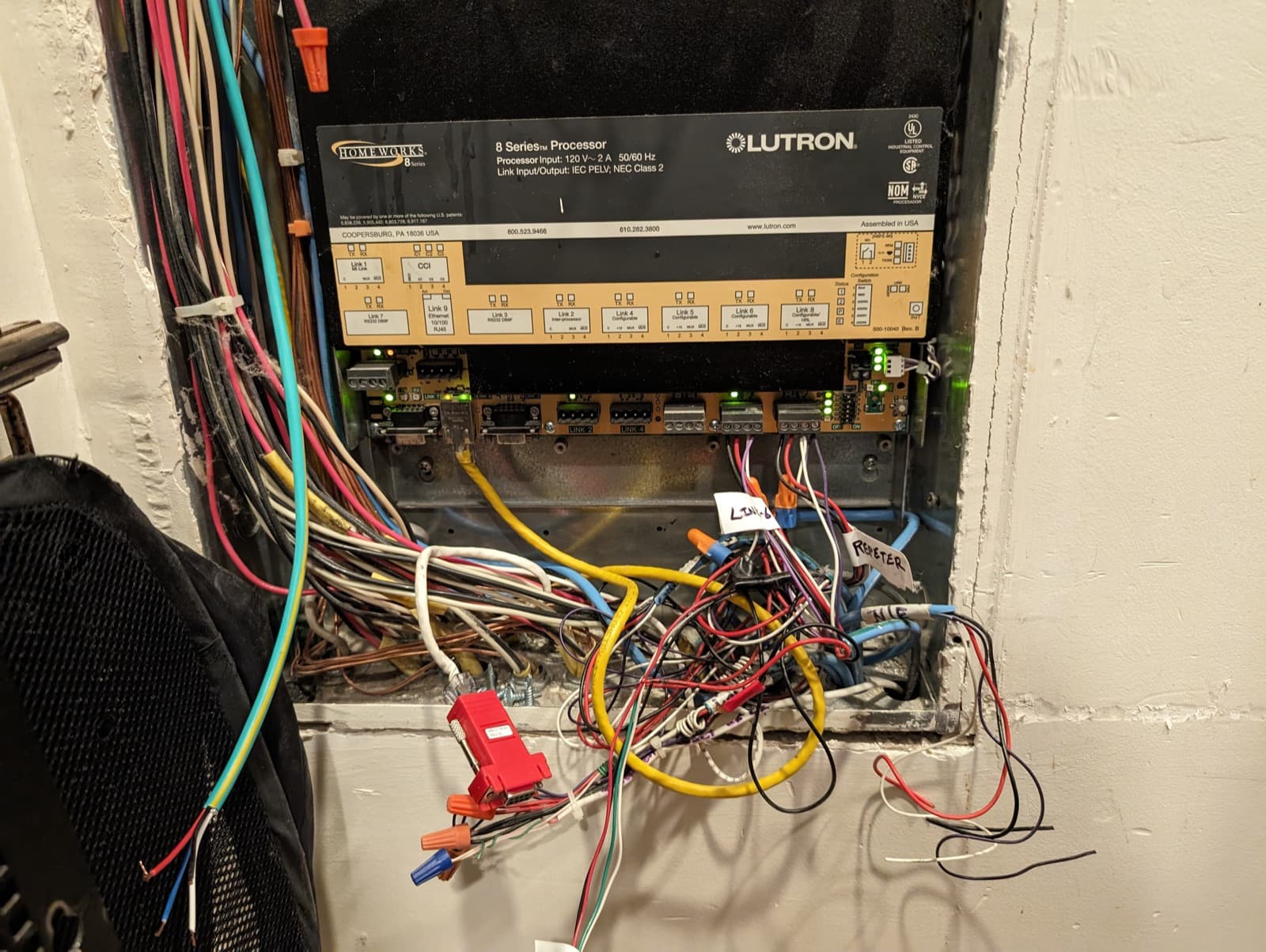 A legacy Lutron HomeWorks processor in a crowded panel of aging wiring